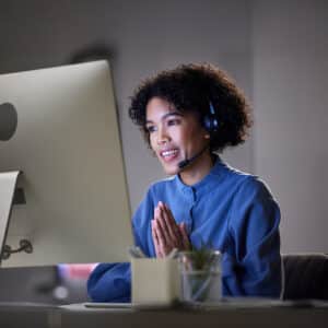 Computer video conference, customer support and professional woman consultation, discussion or conversation. Virtual meeting contact, call center or night consultant with thank you gesture on webinar.