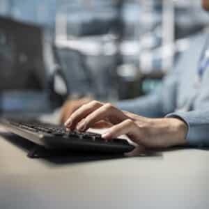 IT technician typing on PC keyboard, programming diagnostic application scripts examining infrastructure.
