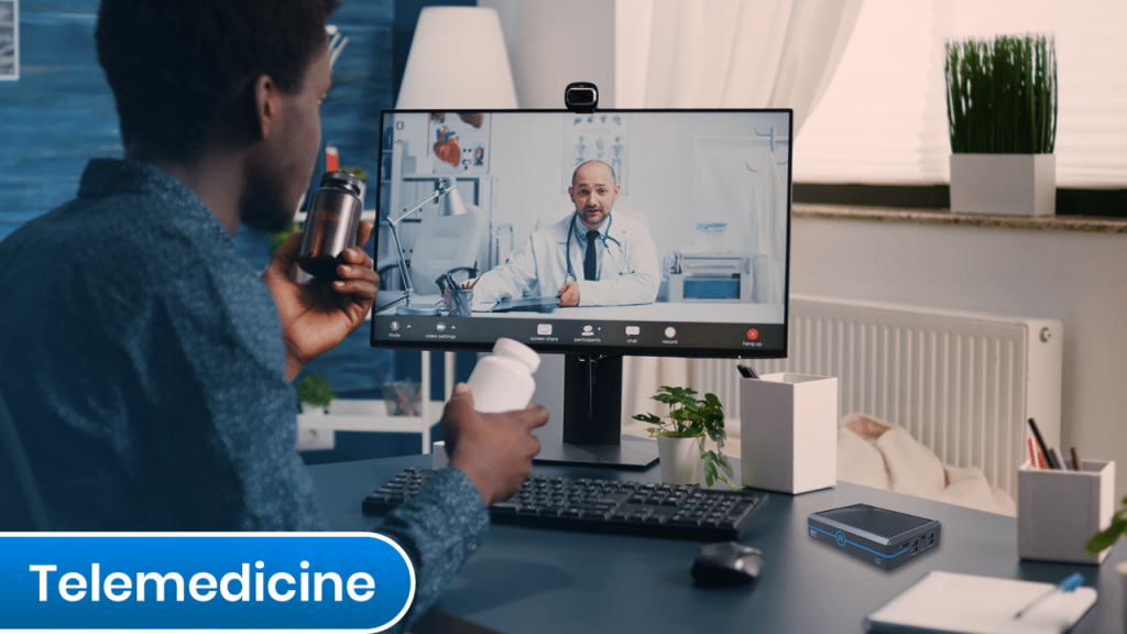 A man sitting at a desk with an Azulle Mini PC displaying telemedicine.