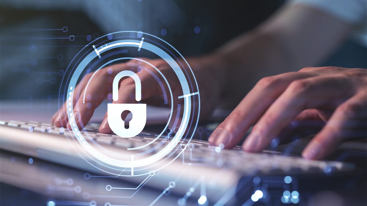 Hands typing on a keyboard with a digital overlay of a security padlock symbol, representing cybersecurity and combating malware.