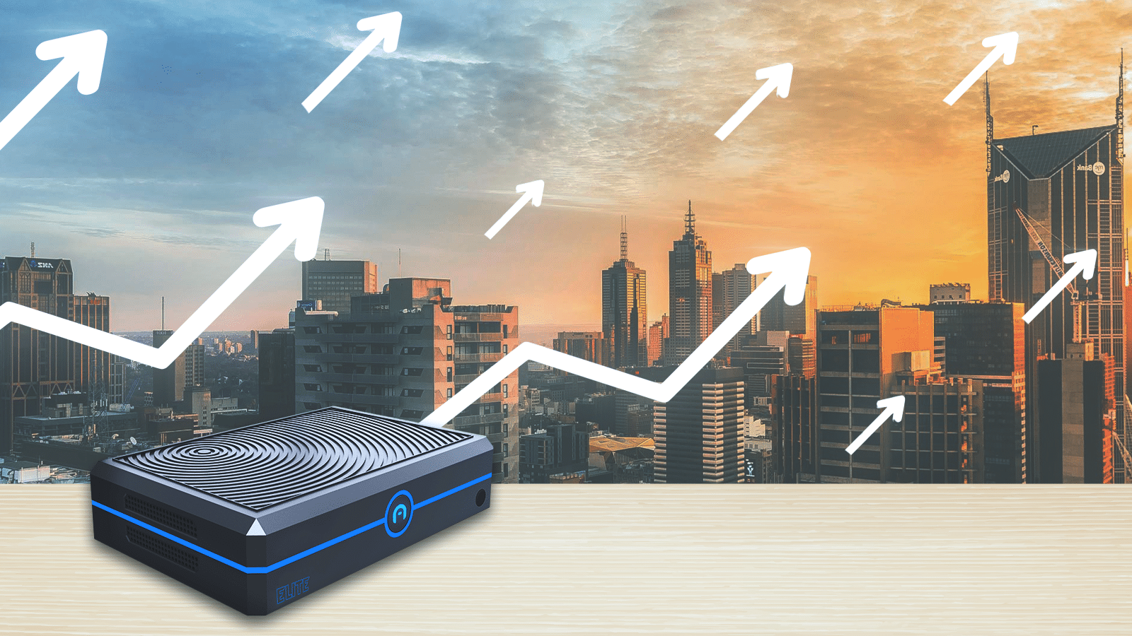 A skyline with skyscrapers during sunset, with an IT device in the foreground. White arrows pointing upwards are superimposed on the image, indicating scalable IT infrastructure.