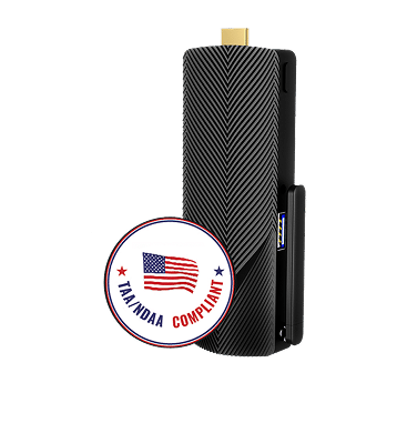 Black rectangular electronic device with a textured surface, a small gold connector on top, and a circular "TAMANDAA COMPLIANT" badge featuring an American flag in the foreground.
