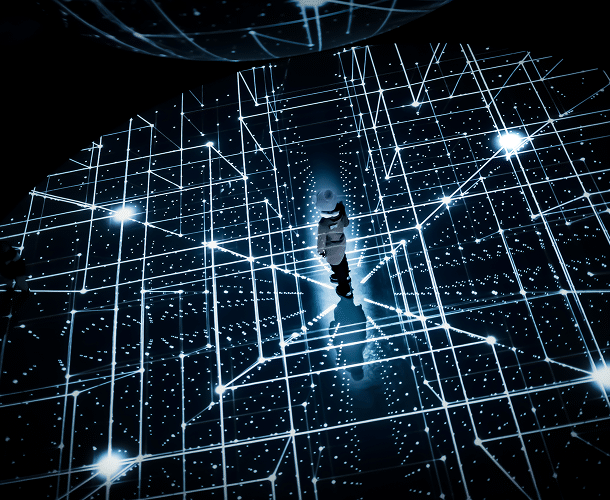 A person standing in the center of a dark room illuminated by intersecting blue and white digital grid lines resembling a virtual or futuristic environment.