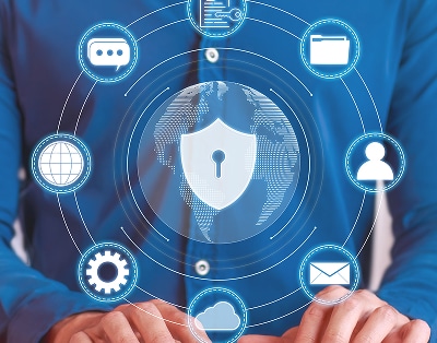 Person typing with cybersecurity icons, including a lock, email, cloud, user, and settings, interconnected around a digital globe on a blue background.