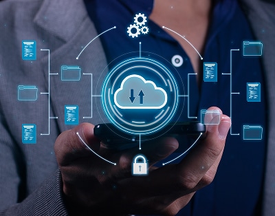 Person holding a smartphone with a digital illustration of cloud storage, data transfer, folders, gears, and a lock overlayed, symbolizing cloud computing and data management.