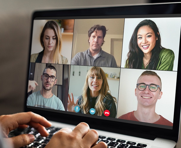 A person participates in a video conference call with five other people, shown in separate boxes on a laptop screen.
