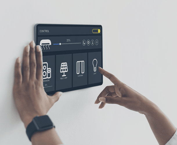 Person uses a wall-mounted smart home control panel to adjust settings for air conditioning, table lamp, curtains, and lighting.