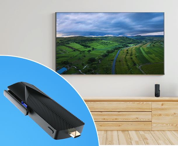 A black streaming device is shown in the foreground, with a TV displaying a landscape image mounted on a wall above a wooden cabinet in the background.