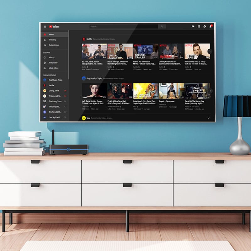 Large-screen TV placed on a white dresser in a modern living room setting.
