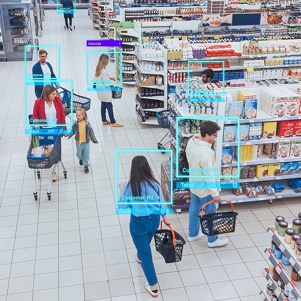 Overhead view of people grocery shopping with digital boxes and labels identifying customers, names, and total purchases, indicating the use of tracking technology in the store.