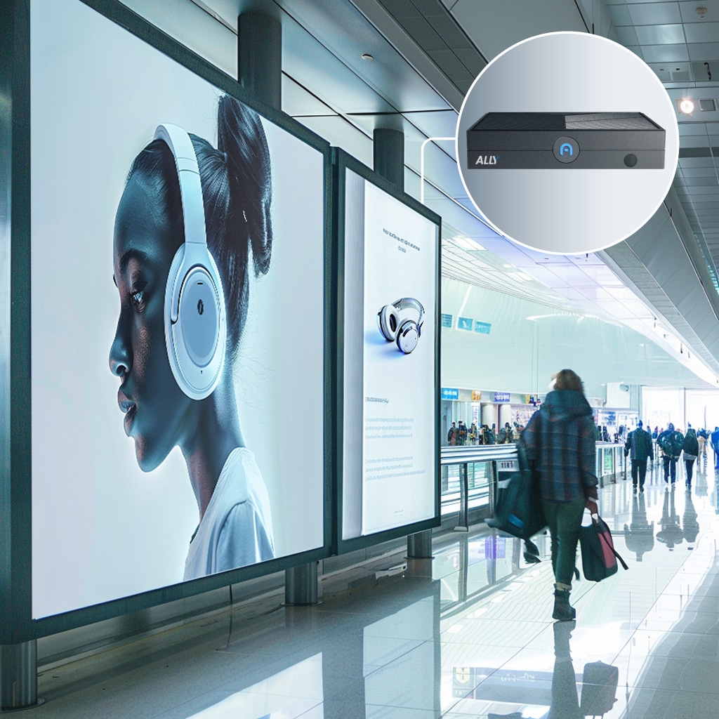 Large digital billboard in airport shows a woman wearing headphones; a circular inset highlights a close-up of an electronic device labeled “ALLY.”.
