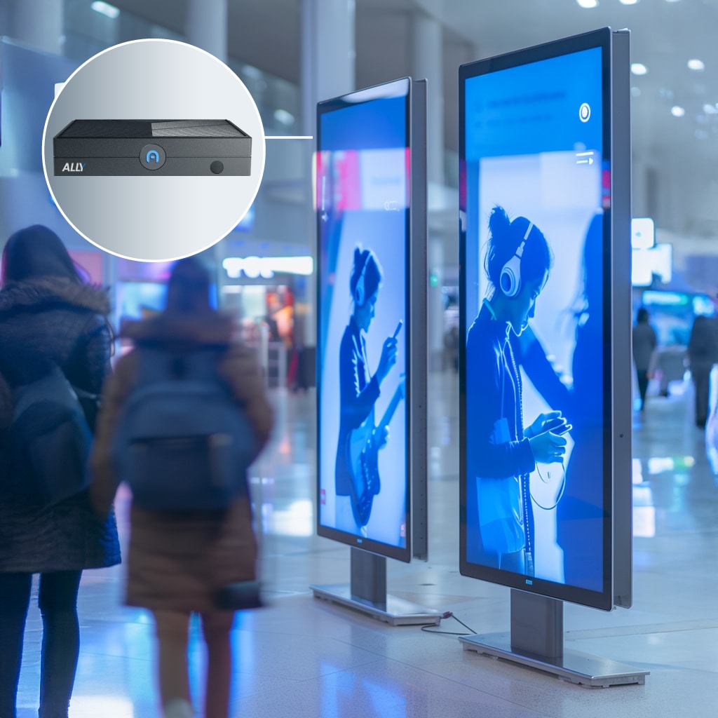 Digital advertising screens display blue-toned images of people in a public indoor space; inset shows a close-up of an ALD-branded electronic device.