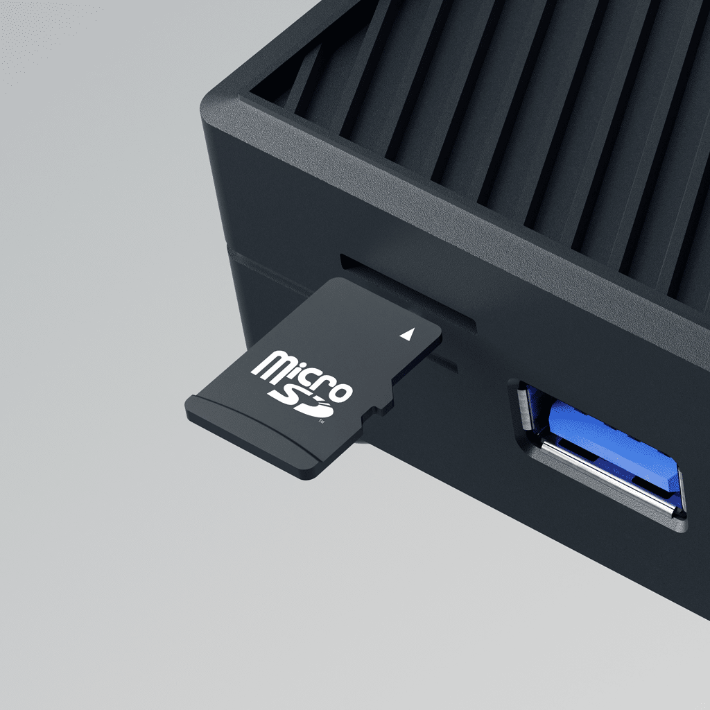 A close-up of a MicroSD card partially inserted into a slot on a black electronic device, next to a blue USB port.